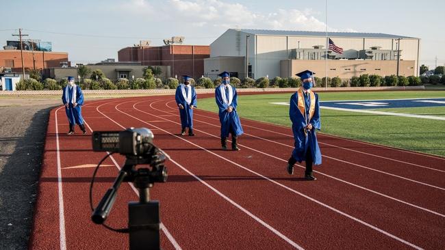 A camera providing a feed for a livestream records students walking to their seats during a graduation ceremony at Fort Stockton High School in Fort Stockton, Texas. Picture: Cengiz Yar