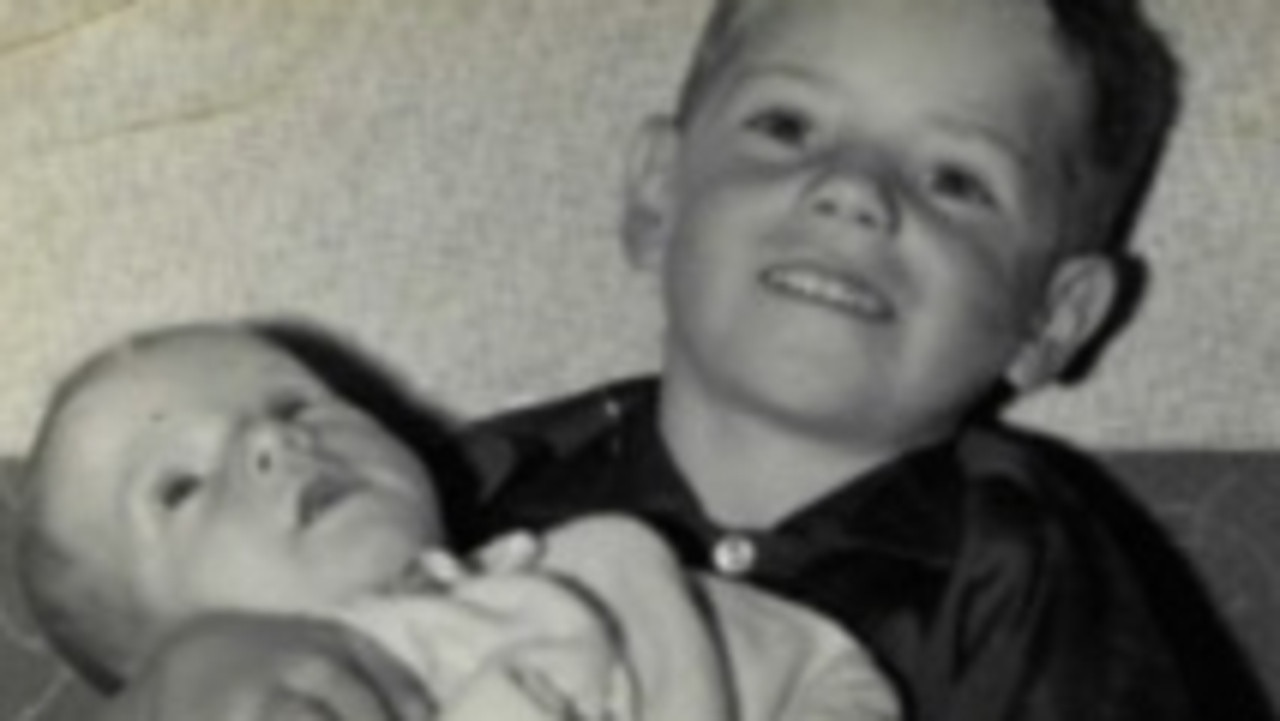 Peter Gleeson, aged 4, holds his younger brother Daryl in 1967.