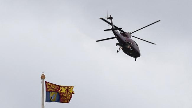 A helicopter is pictured flying above a Royal Standard flag, as it takes off from the grounds of Buckingham Palace.