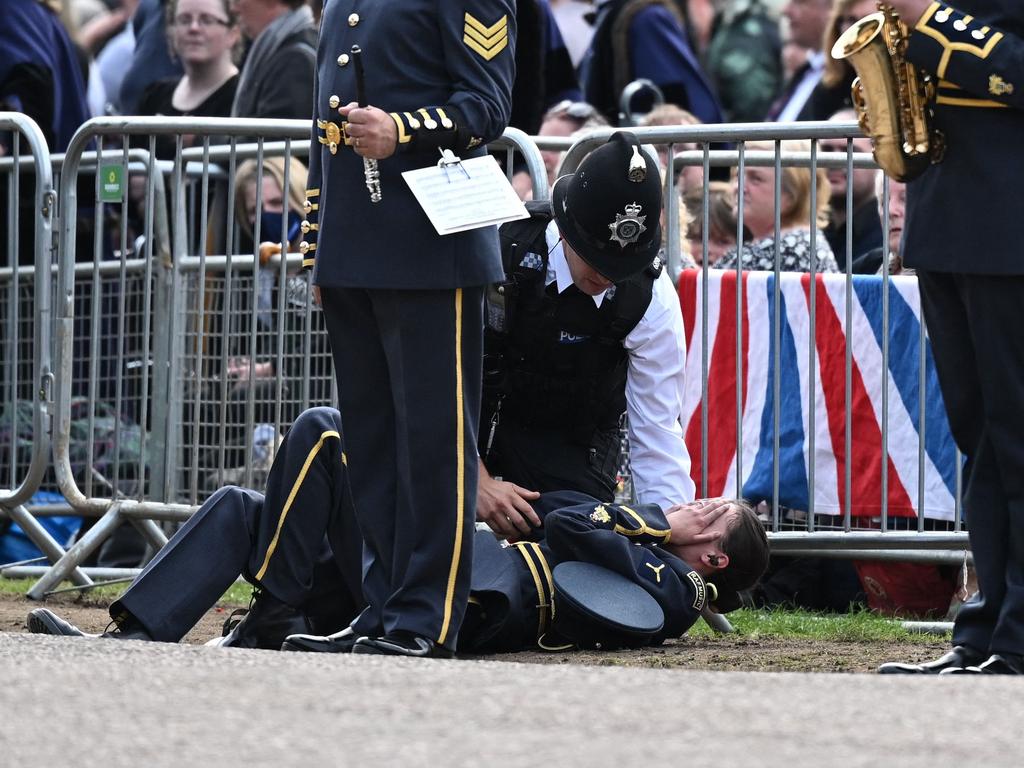 An RAF bandsman is helped after falling ill on The Long Walk in Windsor. Picture: AFP