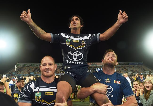 Johnathan Thurston carried off the field by team mates Matt Scott and Gavin Cooper. Picture: Zak Simmonds