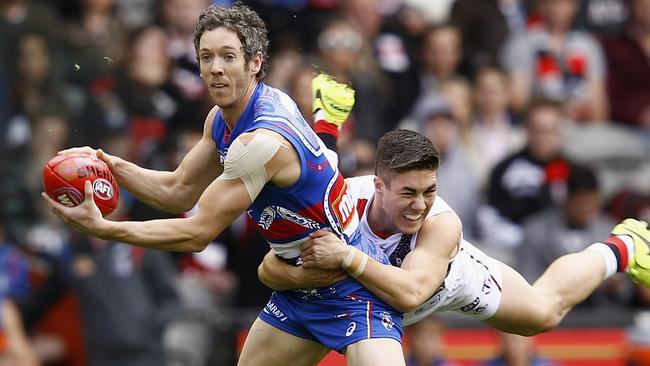 Bob Murphy looks to handball while being tackled by Jade Gresham.