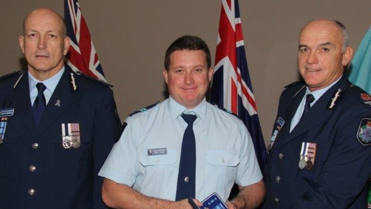 Senior Constable Brett Forte (centre) receives a service medal during his time at Caboolture Police Station.