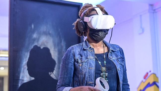 A woman tries out a virtual reality headset. Picture: Simon Maina/AFP