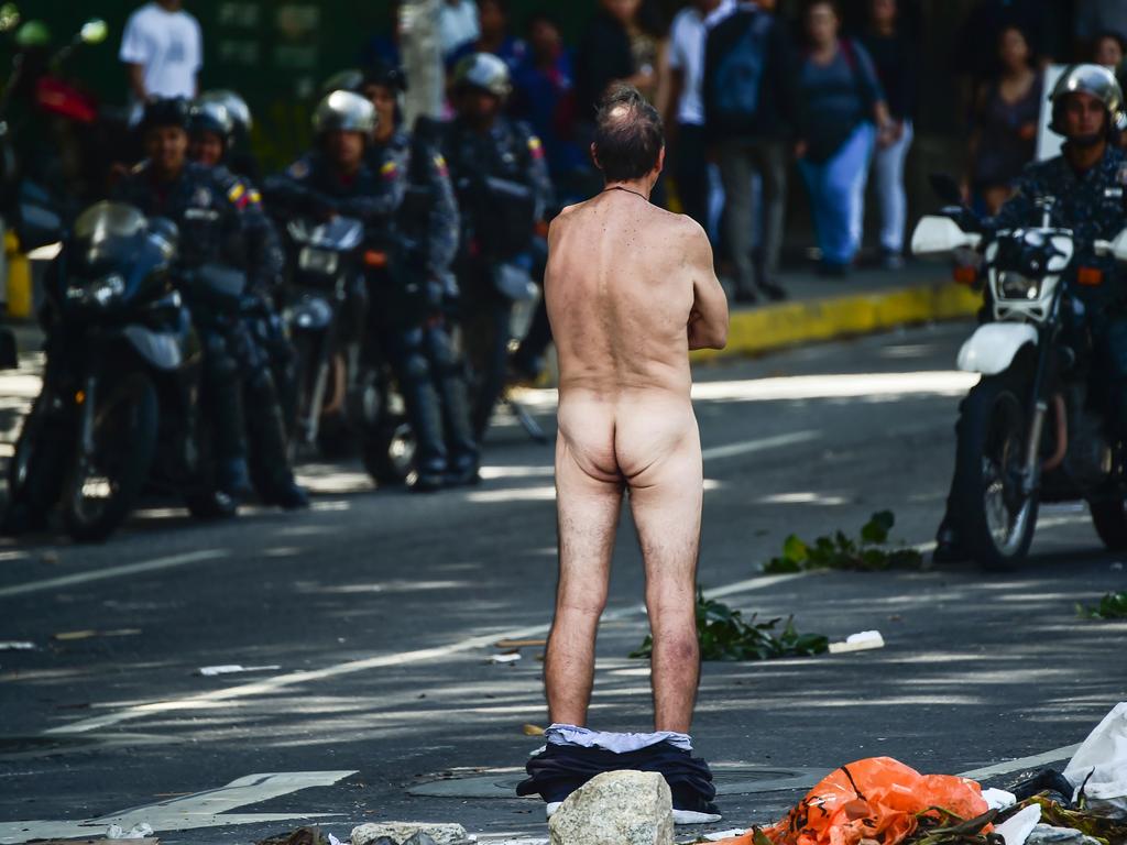 An anti-government activist stands in front of security forces with his trousers down at a barricade set up on a street of Caracas to protest against Venezuelan President Nicolas Maduro. Picture: AFP PHOTO / Ronaldo SCHEMIDT