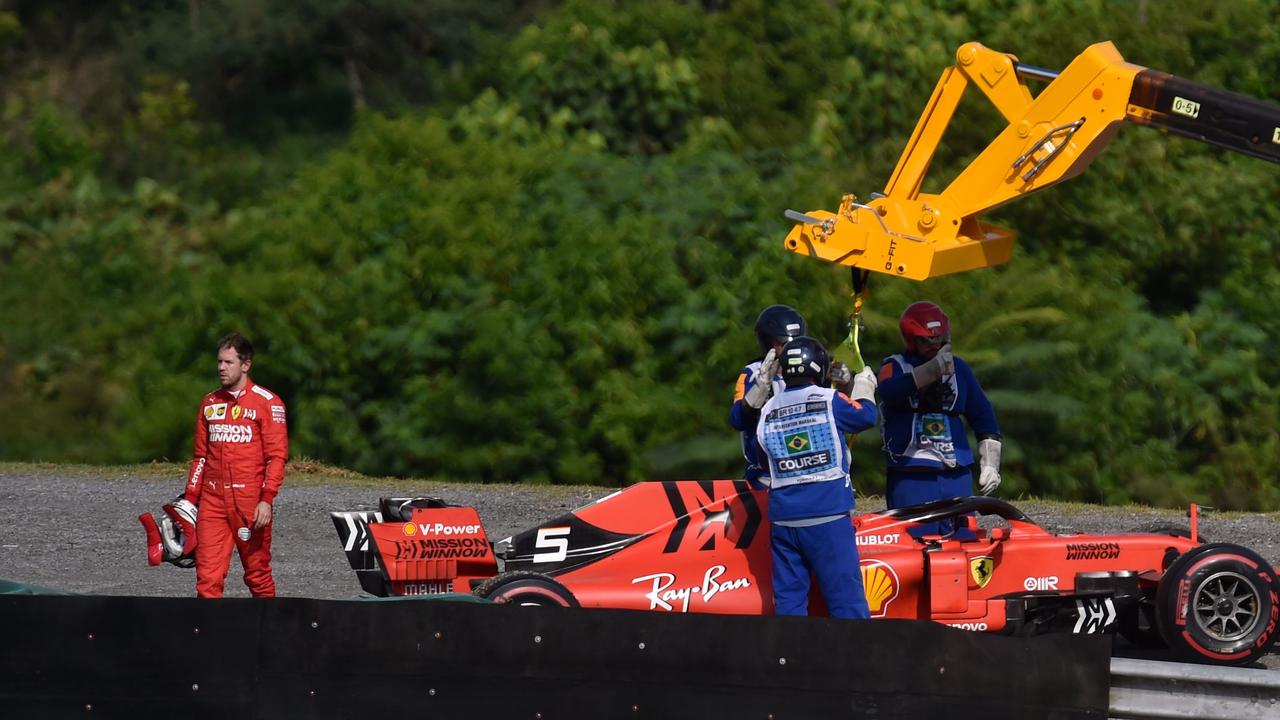 Sebastian Vettel reacts while a crane lifts his car. Picture: Douglas Magno