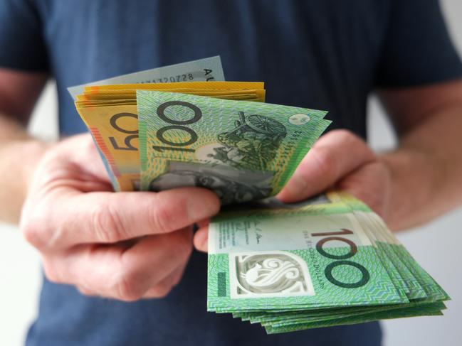 A man counting Australian dollar bills. A picture that describes buying, paying, handing out money, or showing money. Australian cash money generic