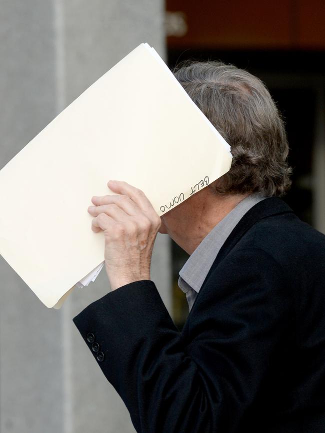 Russell Trim covers his face outside the Federal Court. Picture: Greg Higgs