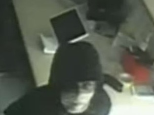 This image shows the masked thief looking at the CCTV camera in Pound of Pizza as her searches for items to steal.