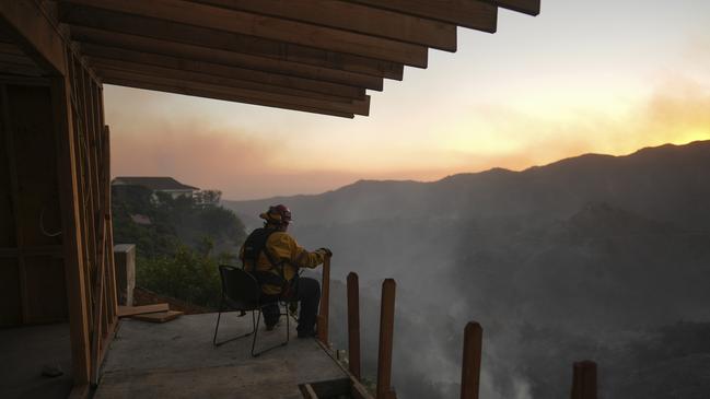 A firefighter rests as crews battle the Palisades Fire in Mandeville Canyon. Picture: AP Photo