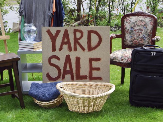 A yard sale with various items on a lawn. See also