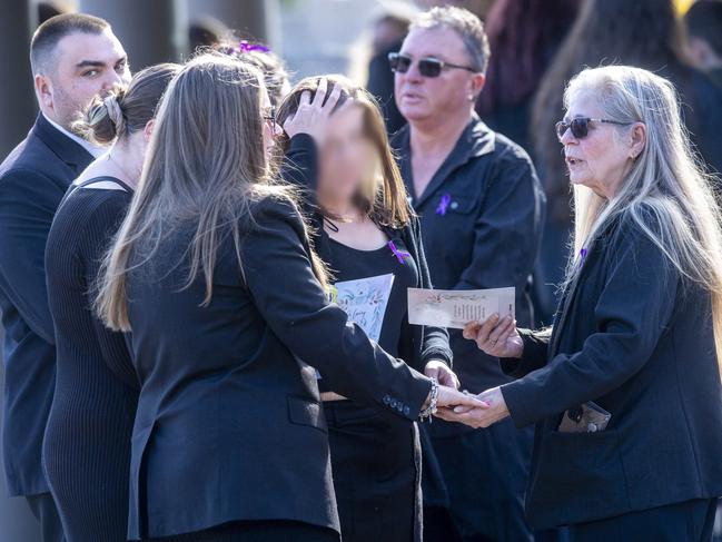 The mother, who cannot legally be identified or pictures, surrounded by mourners. Picture: Jeremy Piper