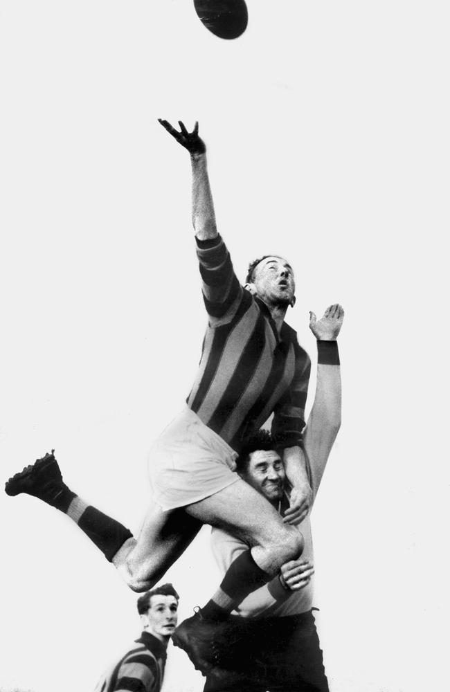 Hawthorn footballer John Kennedy leaps over South Melbourne’s Jack Garrick in 1954.