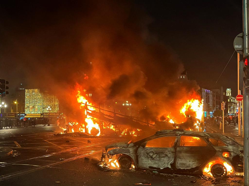 Flames rise from the car and a bus, set alight at the junction of Bachelors Walk and the O'Connell Bridge, in Dublin. Picture: AFP