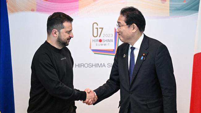 Japan's Prime Minister Fumio Kishida (R) shakes hands with Ukraine's President Volodymyr Zelensky during their bilateral meeting following the conclusion of the G7 Summit Leaders' Meeting in Hiroshima.