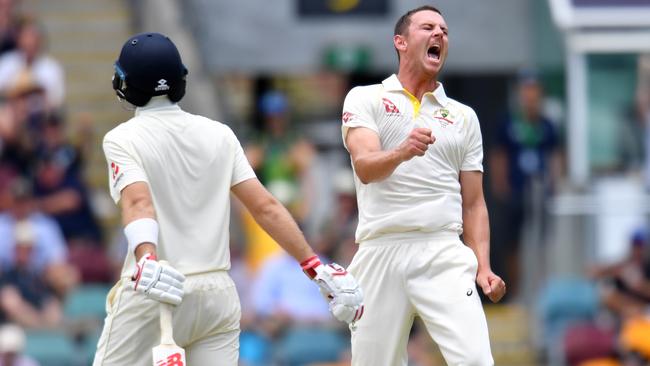 Australian paceman Josh Hazlewood celebrates taking the wicket of England captain Joe Root (left) at the Gabba on Sunday.