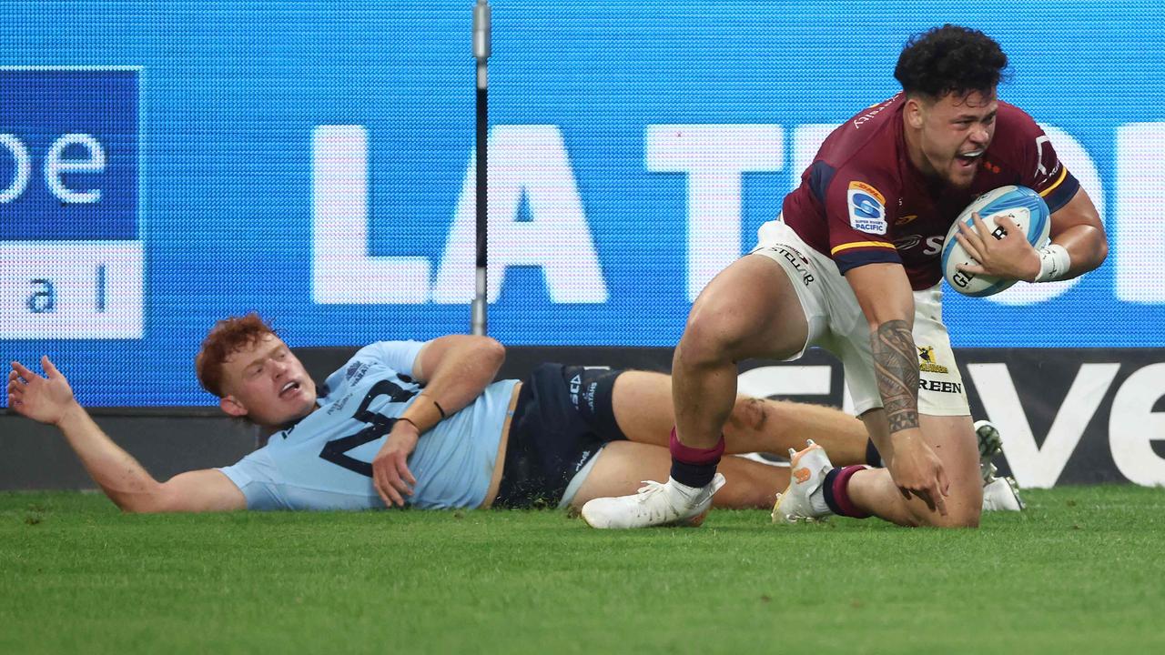 Highlanders' Caleb Tangitau celebrates a successful try after Waratahs' Tane Edmed misses a tackle. Picture: AFP