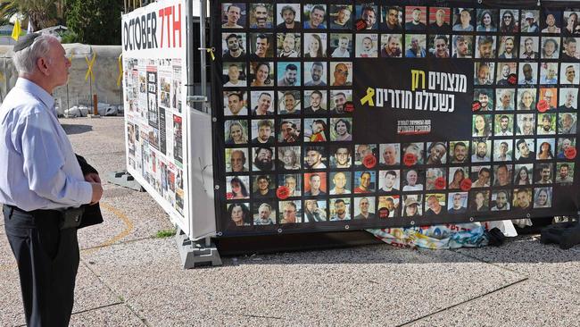 A man looks at the portraits of Israeli captives at the main gathering place for families of hostages held in the Gaza Strip since the October 7, 2023, attacks by Hamas militants, in Tel Aviv on January 21. Picture: AFP