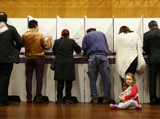 Olivia Dargan - 5 sits patiently with her book as her mum Lee votes at Abbostford Public school in the seat of Reid. Federal Election voting at Abbotsford Public school, Abbotsford in the Federal seat of Reid. picture: John Appleyard