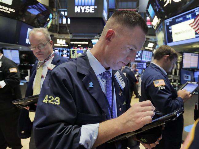 Trader Justin Flinn, center, works on the floor of the New York Stock Exchange, Tuesday, July 5, 2016. U.S. stocks are falling Tuesday morning as investors worry about the British financial system. (AP Photo/Richard Drew)
