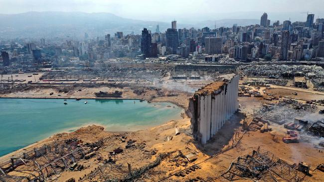 An aerial view shows the massive damage done to Beirut port's grain silos (C) and the area around it on August 5, 2020, one day after a mega-blast tore through  the harbour in the heart of the Lebanese capital with the force of an earthquake, killing more than 100 people and injuring over 4,000. - Rescuers searched for survivors in Beirut in the morning after a cataclysmic explosion at the port sowed devastation across entire neighbourhoods, killing more than 100 people, wounding thousands and plunging Lebanon deeper into crisis. (Photo by - / AFP)