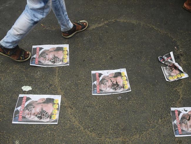 A Muslim demonstrator walks over picture of French President Emmanuel Macron with a footprint over his face during an anti-France protest near the French consulate in Kolkata. Picture: AFP