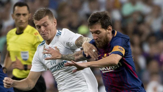 Real Madrid's German midfielder Toni Kroos (L) vies with Barcelona's Argentinian forward Lionel Messi.