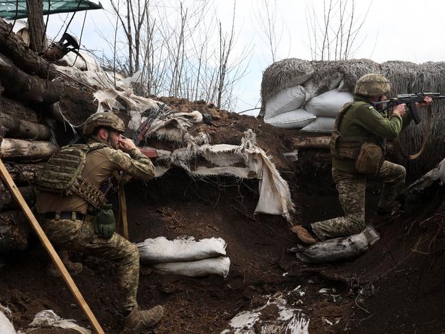 Ukrainian soldiers shoot with assault rifles in a trench on the front line with Russian troops in Lugansk region. Picture: AFP