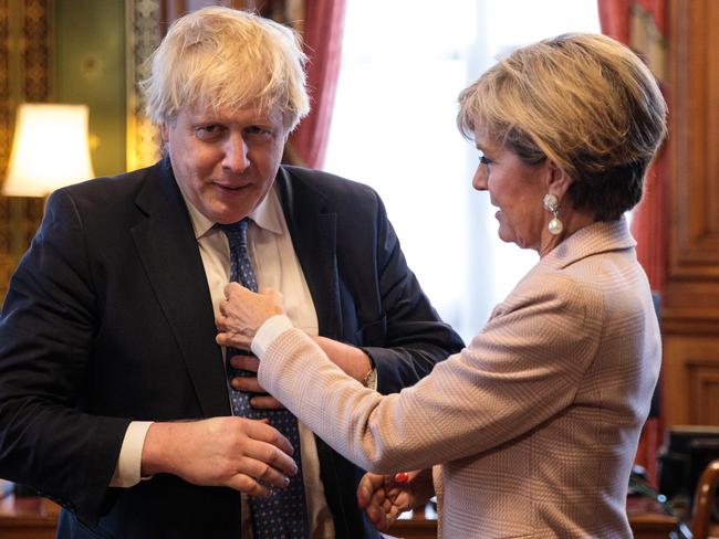 Then British Foreign Secretary Boris Johnson has his tie straightened by his then Australian counterpart Julie Bishop in his office, February 2017. The two enjoyed a convivial friendship. Picture: Jack Taylor/Getty Images