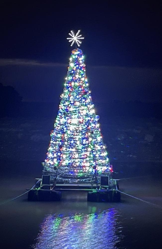 Residents prepare the Sutherlands Creek's Floating Christmas Tree at night. Picture: Supplied