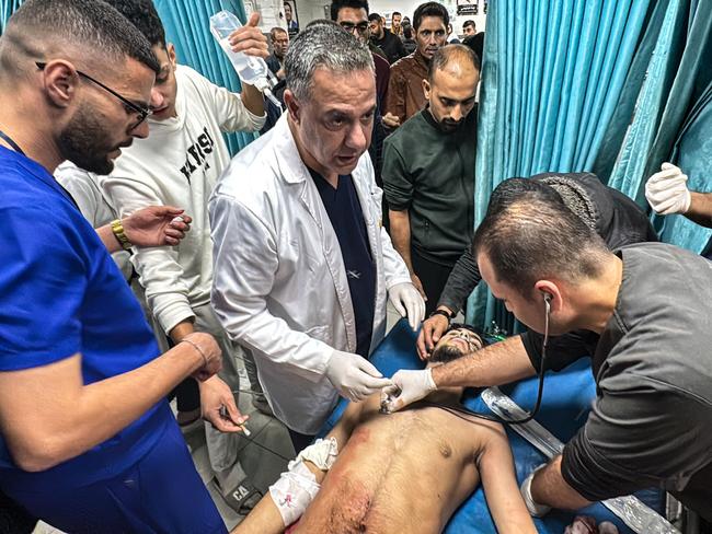 (FILES) Hossam Abu Safieh (C), director of the Kamal Adwan Hospital, supervises the treatment of a Palestinian man,  injured in an Israeli strike on Beit Lahia in the northern Gaza Strip on November 21, 2024. Detained on suspicion of being a Hamas militant, Hossam Abu Safiyeh, head of a major hospital in Gaza that was raided by Israeli forces last week, has become the face of a crumbling healthcare system in the war-ravaged Palestinian territory. (Photo by AFP)