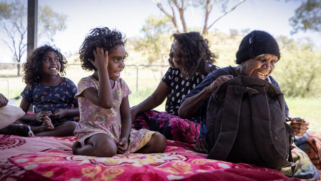 In a town camp on the outskirts of Alice Springs are, from left, Monica, 8, Tilana, 5 and their great grandmother Susan Chalmers Hayes (far right). Picture: Liam Mendes