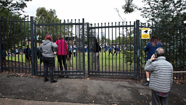 Parents wait outside Castle Hill High School after it had to be evacuated over email threats on the 27th of October. Picture: Adam Yip