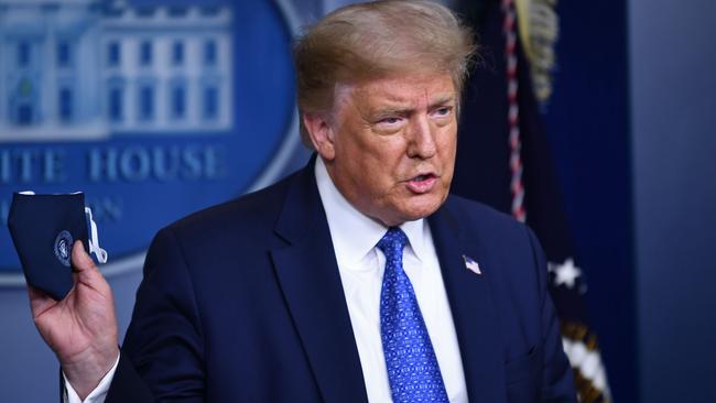 Donald Trump holds a face mask during the renewed daily briefing. Picture: AFP.