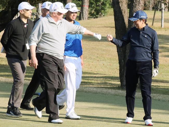 Mr Trump fist-bumps Japanese Prime Minister Shinzo Abe while playing golf at the Kasumigaseki Country Club Golf Course in Kawagoe, outside Tokyo. Picture: Japan’s Cabinet Public Relations Office via Jiji Press/AFP photo