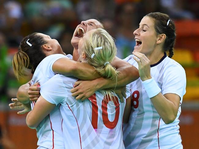 Norwegian players celebrate their victory at the end of the women's preliminaries Group A handball match Spain vs Norway for the Rio 2016 Olympics Games at the Future Arena in Rio on August 8, 2016. / AFP PHOTO / FRANCK FIFE