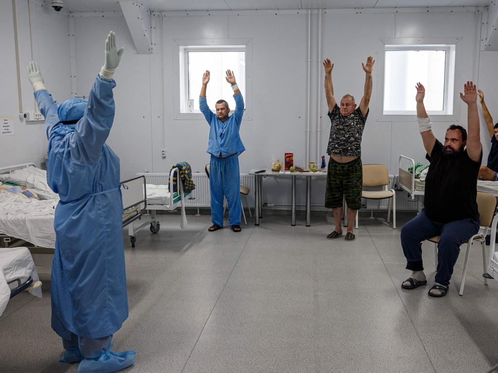 A medic and Covid-19 coronavirus patients perform breathing exercises as part of physiotherapy in the Moscow Sklifosovsky hospital in Moscow. Picture: AFP