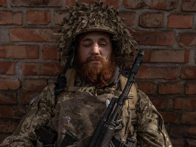 A Ukrainian infantry soldier of the 23rd Mechanized Brigade sits as he waits to deploy toward the frontline in the Avdiivka direction, in the Donetsk region (Photo by Roman PILIPEY / AFP)