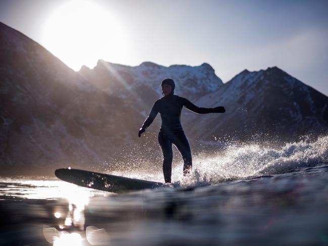 A surfer rides a wave on March 10, 2018 in Unstad, northern Norway, Lofoten islands, within the Arctic Circle as air temperature drops minus 13°C and water temperature above 4°C. Picture: AFP