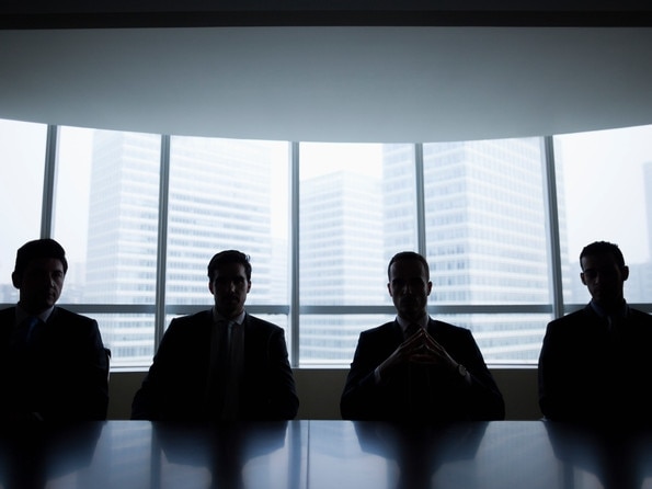 Silhouette row of businessmen sitting in meeting roomMen boardroom business company directors