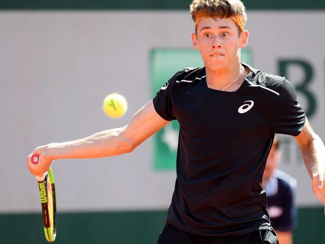 Australia's Alex De Minaur plays a return to Britain's Kyle Edmund during their men's singles first round match on day three of The Roland Garros 2018 French Open tennis tournament in Paris on May 29, 2018. / AFP PHOTO / CHRISTOPHE ARCHAMBAULT