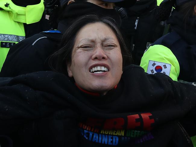 SEOUL, SOUTH KOREA - JANUARY 02: Police officers remove pro-Yoon Suk Yeol supporters outside the official residence of impeached South Korean President Yoon Suk Yeol on January 02, 2025 in Seoul, South Korea. A Seoul court issued a warrant to detain impeached President Yoon Suk Yeol over his botched martial law imposition, making him the first sitting South Korean president to face arrest. (Photo by Chung Sung-Jun/Getty Images)