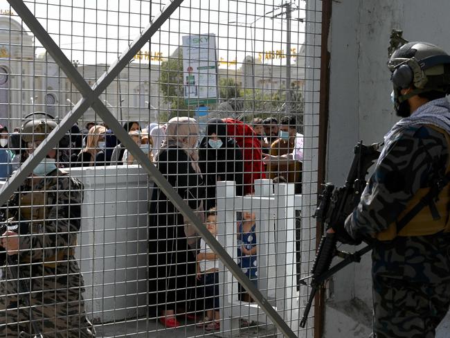 Taliban Badri fighters, a special forces unit, stand guard as Afghan wait at the main entrance gate of Kabul airport to leave Afghanistan in Kabul. Picture: AFP