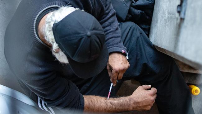 A man is seen injecting in a carpark next to North Richmond Community Health. Picture: Sarah Matray