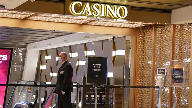 A security guard patrols a closed entrance in Crown casino. Picture: AAP Image/Scott Barbour