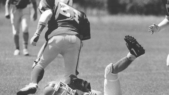 Stingers player Steven Chung bowls over Tigers’ Kenny Cracknell during a gridiron match at Gardens in the mid-90s. Picture: File.