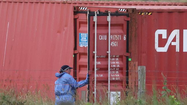 Police look inside a container while investigating the death of a mother at a property at Woodhill. Picture: Nigel Hallett