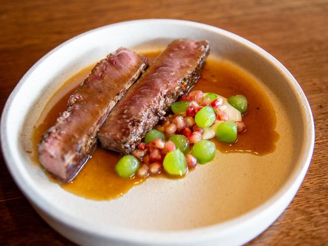 Malik’s lamb dish comes to the table sliced, for easy sharing, and is served with a bright pop of pomegranate seeds and a tahini sauce. Picture: Linda Higginson