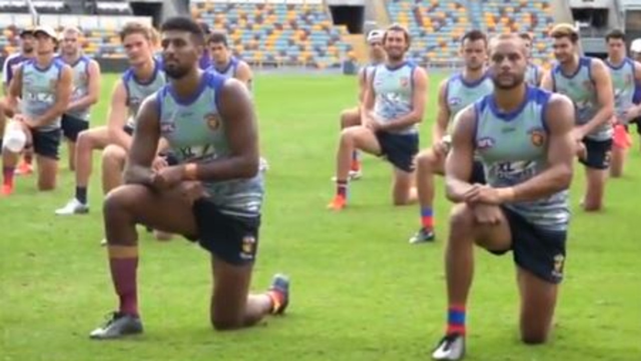 Brisbane Lions players kneeling down at training.