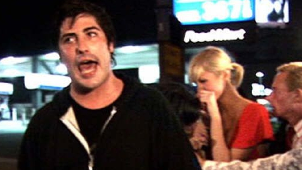 Socialite Brandon Davis mouths off about actress Lindsay Lohan while socialite Paris Hilton laughs in the background.